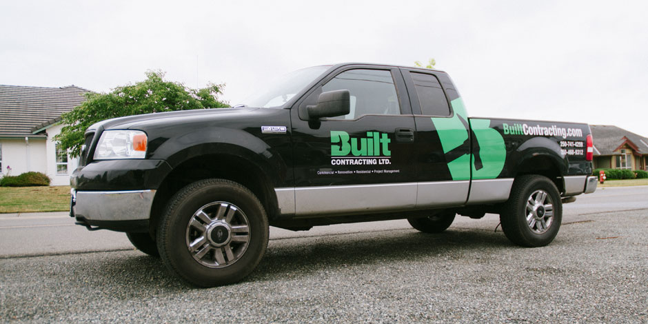 A black pickup truck with Built Contracting Ltd. branding on the side is parked on a residential street.