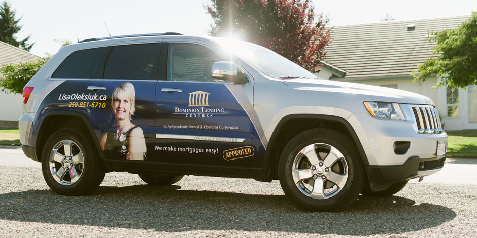 A silver SUV features advertising for Dominion Lending Centres, showcasing contact information and an image of a woman on the side. The text reads: "We make mortgages easy!" and a phone number is displayed.